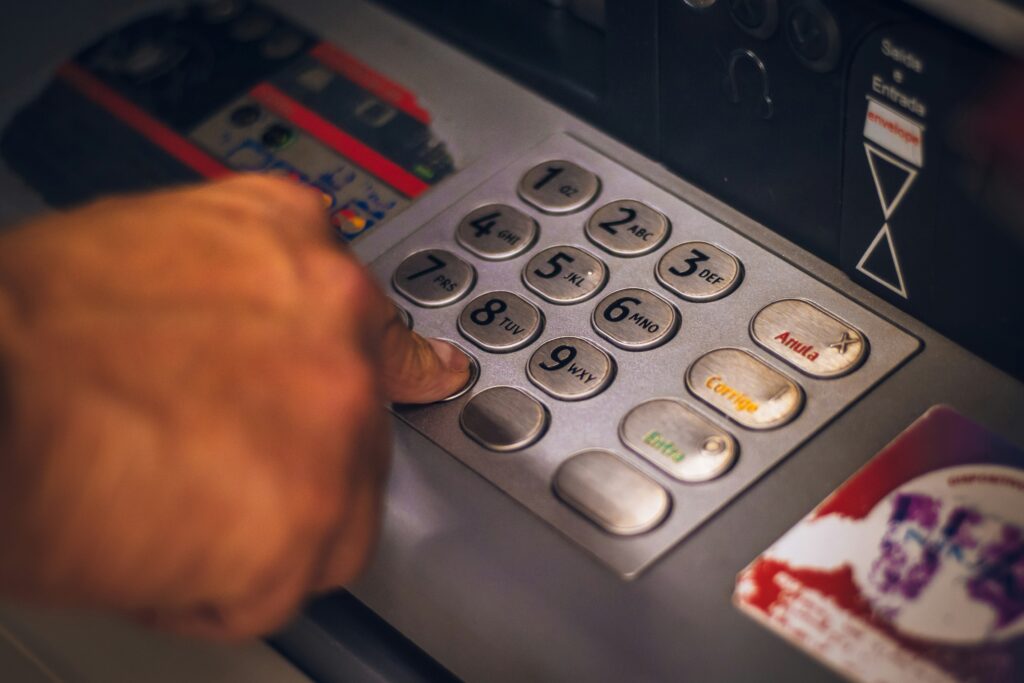 A person entering their PIN on an ATM keypad