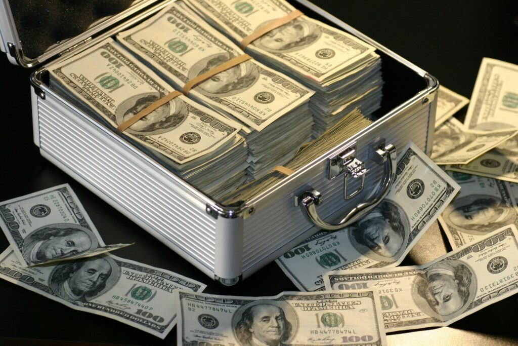 An open briefcase filled with stacks of $100 bills, representing wealth, financial success, and large cash transactions